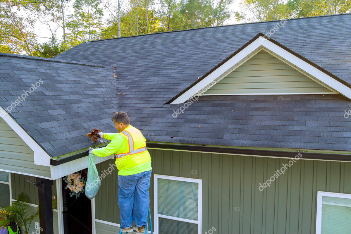 roof gutter cleaning service worker unclogging debris drain
